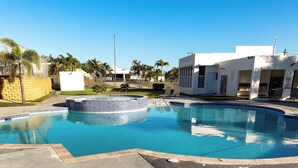 A swimming pool with a hot tub, surrounded by a fenced area and palm trees. - Coastal Retreat Pool Ocean View Fajardo (Fajardo)
