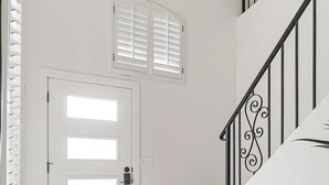 A staircase with a wooden handrail and a metal railing with a decorative design.