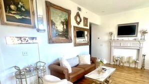 A living room with a brown sofa, a white chair, a coffee table, and a fireplace.