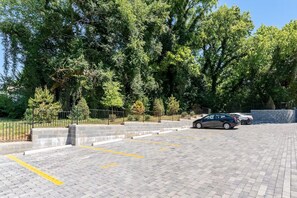A parking area with marked spaces, a paved surface, and a metal fence.