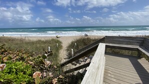 A wooden boardwalk leading to a beach with waves crashing onto the shore. - 4BR House in Ocean Resort w/ Private Beach, Pool, Pickleball, Marina, and More! (Jensen)