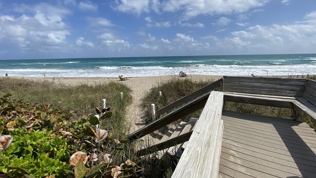 A wooden boardwalk leading to a beach with waves crashing onto the shore. - 4BR House in Ocean Resort w/ Private Beach, Pool, Pickleball, Marina, and More! (Jensen)