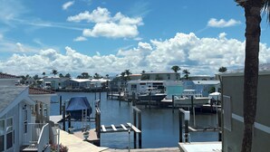A marina with boats docked, a clear sky, and a palm tree. - 4BR House in Ocean Resort w/ Private Beach, Pool, Pickleball, Marina, and More! (Jensen)