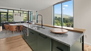 Una cocina moderna con una isla grande, horno empotrado y vistas al exterior.