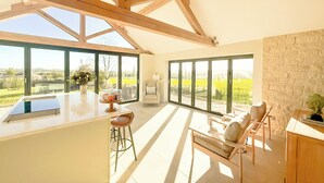 Un'ampia cucina con grandi finestre, una parete in pietra e vista sulla campagna.