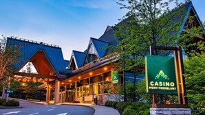 Un bâtiment de casino doté d’une entrée imposante, d’une enseigne indiquant qu’il s’agit de l’établissement de Mont-Tremblant, et d’une façade bien éclairée.
