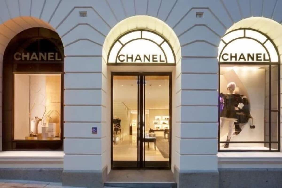 A Chanel store with three arched entrances, each displaying mannequins.