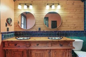 A wooden vanity with two sinks, a mirror, and a light fixture above. - 2 Bedroom 2 bath (Sarasota)