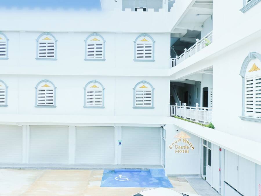 A hotel with multiple balconies, a wheelchair-accessible entrance, and a sign for the Snow White Castle Hotel.