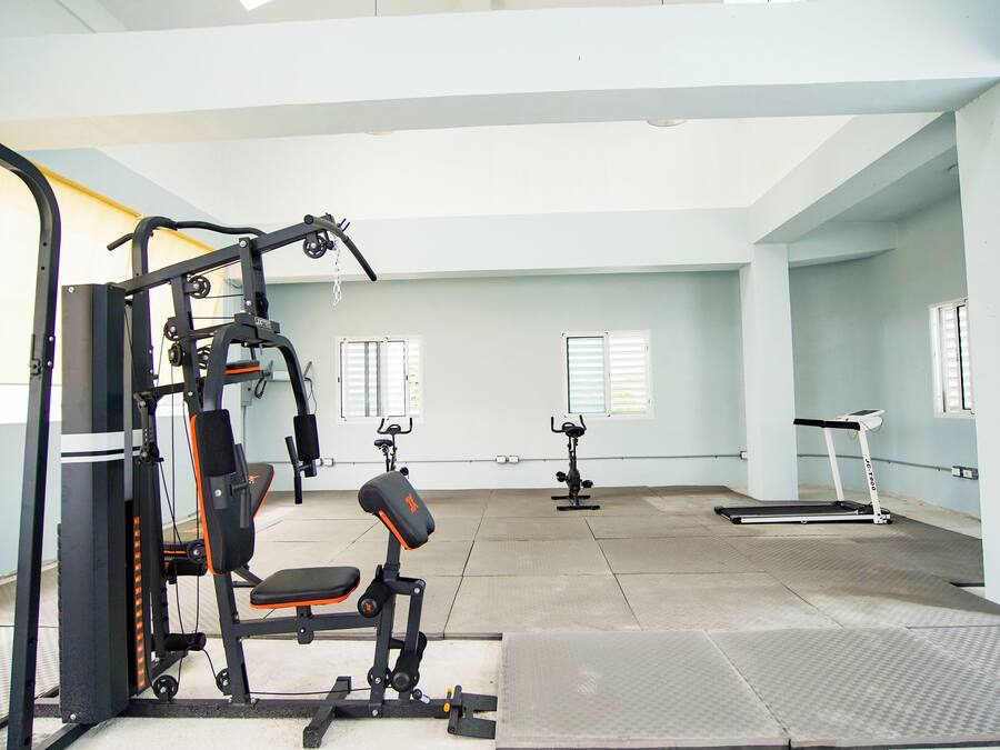 A gym with exercise equipment, a punching bag, and a treadmill.