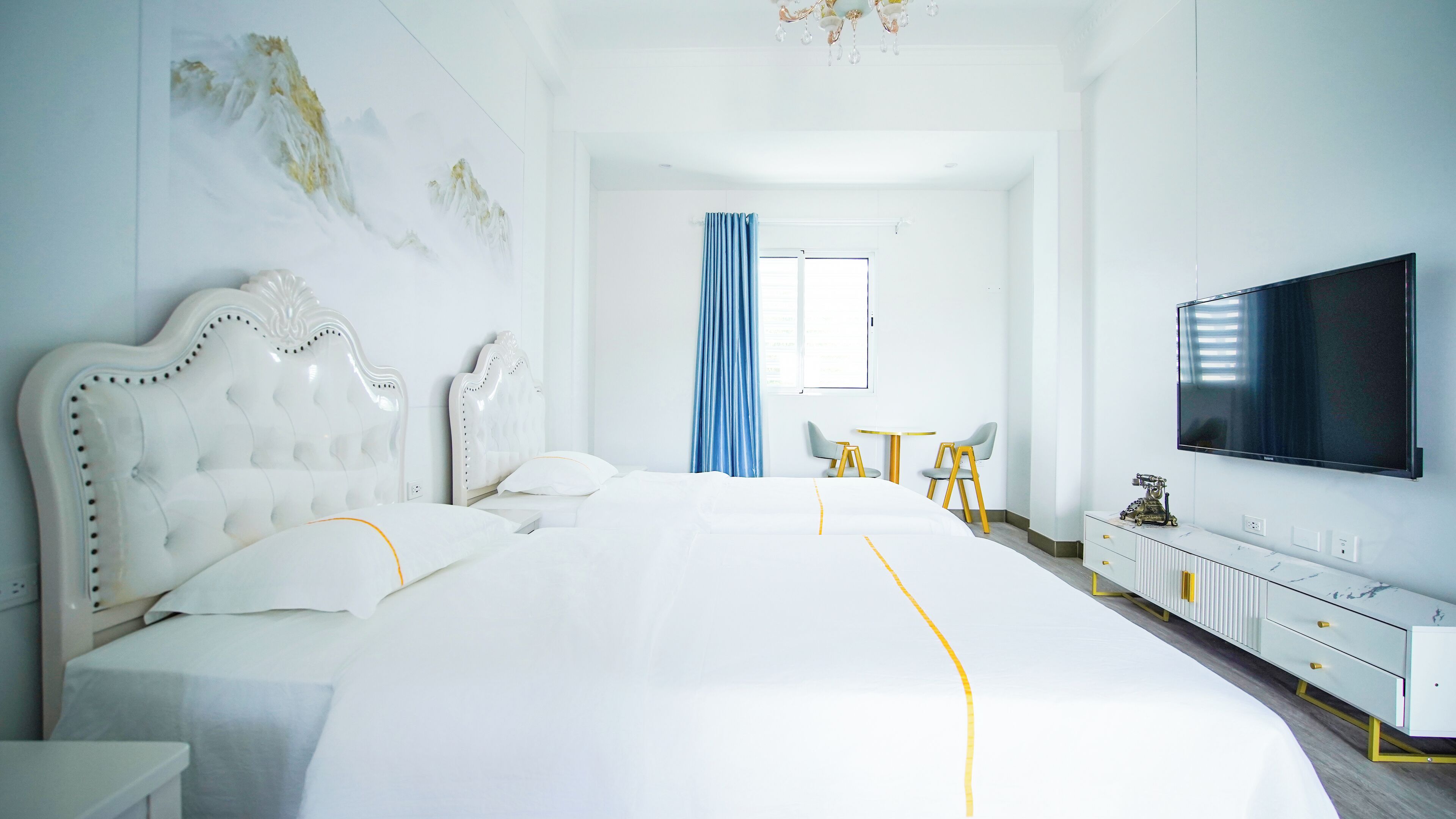 Quarto de hotel espaçoso com uma cama grande, televisão de tela plana, escrivaninha e uma cadeira.