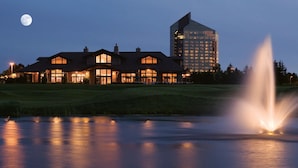 A large hotel with multiple buildings, a visible fountain, and a moon in the sky.