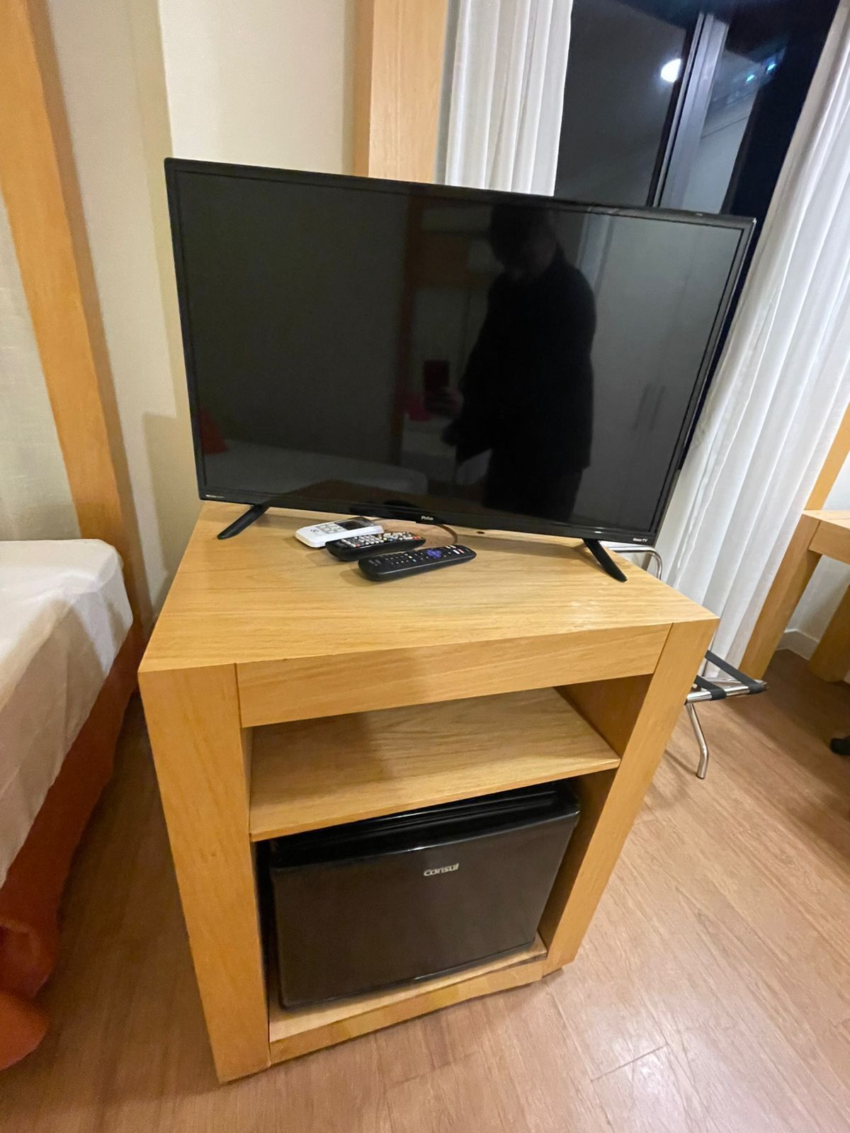 A wooden TV stand with a flat-screen TV and a DVD player.
