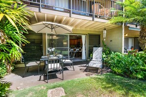 An outdoor patio with a table, chairs, and an umbrella. - 2bd tropical, walk to beach stay (Honokowai)