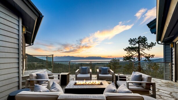A modern outdoor seating area with a fire pit, overlooking a scenic mountain view during sunset. - Tahoe Blue Estate Luxury Retreat LUXE5 (Stateline)