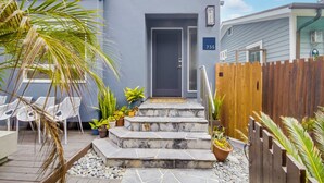 A modern house with a grey door, numbered 735, and a stone staircase leading to the entrance. - A-Wave From It All, Steps to Sand with AC! (San Diego)