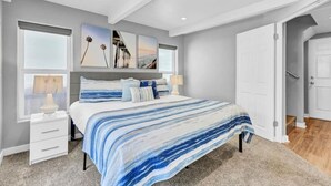 A bedroom with a large bed, two bedside tables, a window with blinds, and a door leading to another room. - A-Wave From It All, Steps to Sand with AC! (San Diego)
