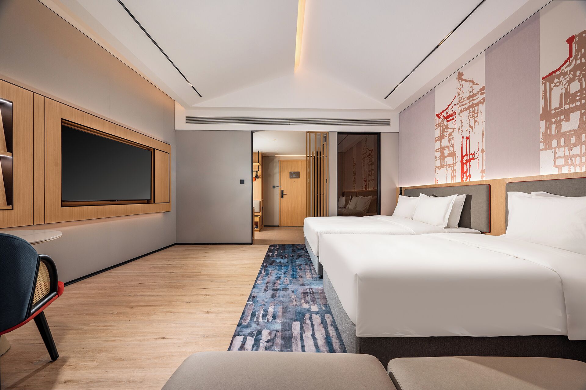 Une chambre d’hôtel moderne, dotée d’un grand lit, d’une télévision et d’un bureau.