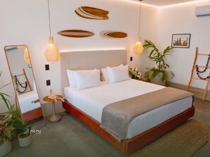Ein modernes Schlafzimmer mit einem großen Bett, Nachttischlampen und Wandbildern.