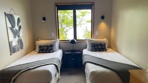 A room with two beds, a window, a lamp, and a wall art piece. - Pukawa Villas (Formerly Oreti Village Resort) (Pukawa)