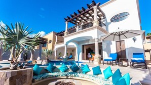 A resort with a pool, outdoor seating, and a two-story building with balconies.