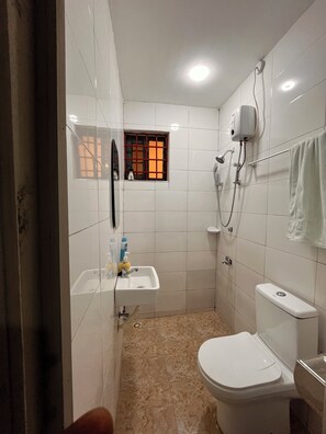 A small, tiled bathroom with a toilet, sink, and shower. - ESPADA LODGE Studio 3.3 (Somanya)