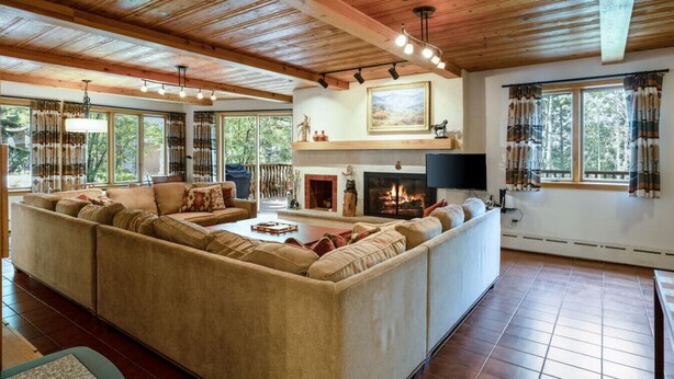A cozy living room with a large sectional sofa, a fireplace, and a TV. - Exclusive Cascade Home - Close to Cascade Lift (Vail)