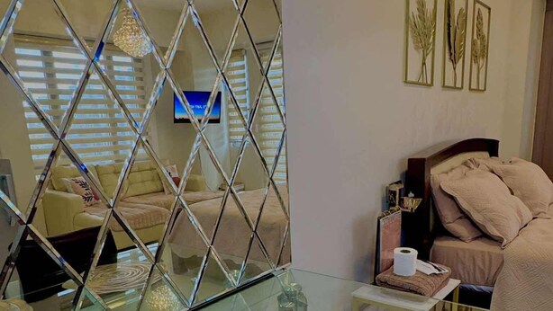 Un salon moderne avec une table basse en verre, un canapé et un téléviseur.