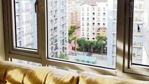 Une pièce dotée d’une grande fenêtre donnant sur un paysage urbain avec de nombreux immeubles de grande hauteur.