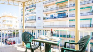 A balcony with a table set for two, chairs, and a bottle of wine. - Apartamentos Solset Nerja C (Nerja)