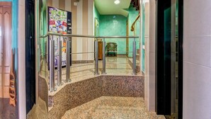 A hotel lobby with a curved staircase, a green wall, and a seating area. - Apartamentos Solset Nerja C (Nerja)