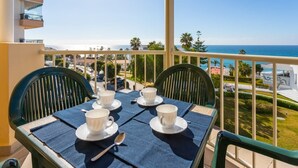 A balcony with a table set for two, overlooking a coastal view. - Apartamentos Solset Nerja A (Nerja)