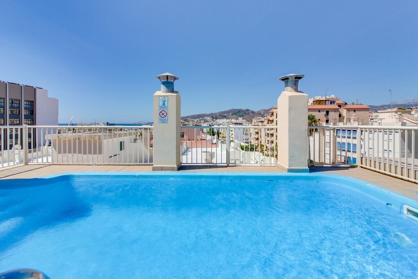 A rooftop pool with a clear view of the surrounding buildings and landscape.