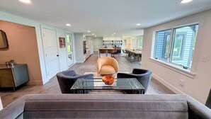 A spacious living area with a sofa, a glass coffee table, and a dining table with chairs. - 9FR Renovated home with beautiful views, large yard, dogs welcome! AC (Bethlehem)