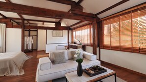 A spacious living room with a sofa, a coffee table, and wooden beams on the ceiling. - Yulong Sadhu Inn (Lijiang)
