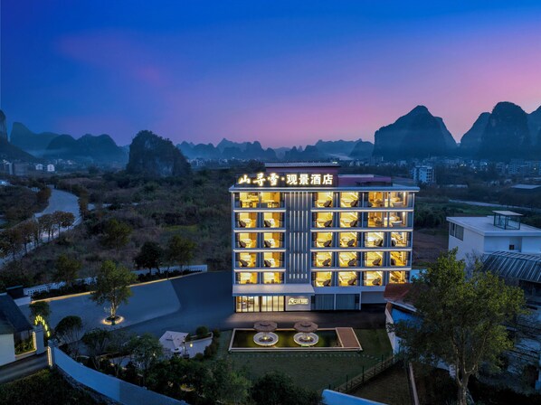 A hotel with multiple floors and a rooftop terrace.