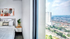 Un dormitorio moderno con un ventanal grande, una cama, una mesita de noche con una planta y arte abstracto en la pared.