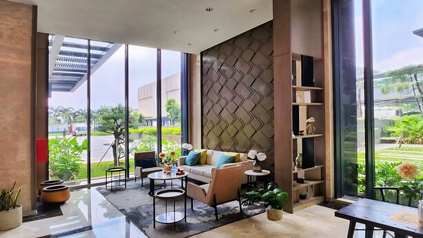 Una sala de estar moderna con sofá, mesa de centro y un amplio ventanal con vistas al exterior.