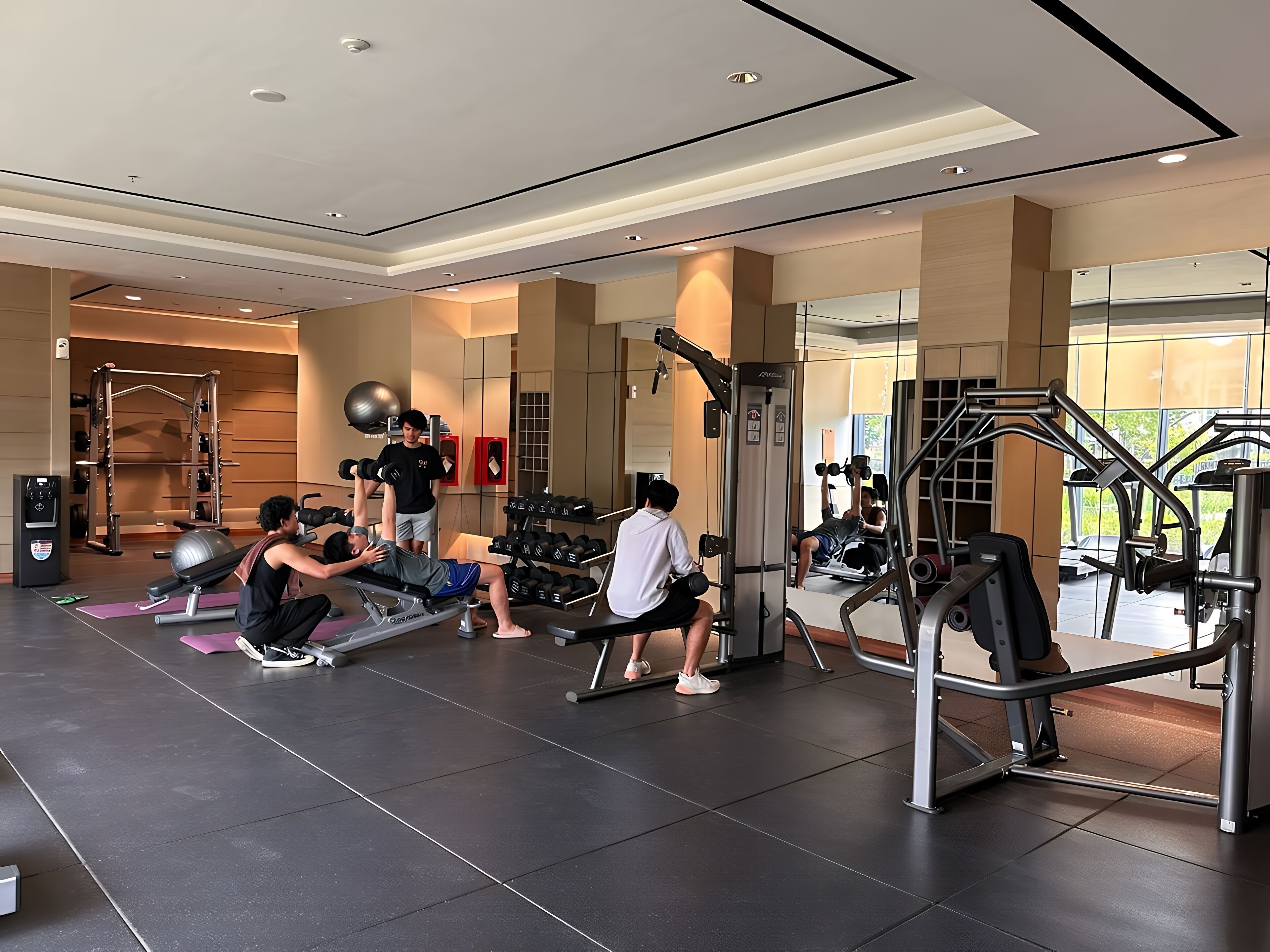 A gym with various exercise equipment, including a bench press, dumbbells, and a squat rack.