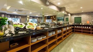 A buffet setup with multiple serving stations, a large mirror, and a variety of dishes displayed on shelves.