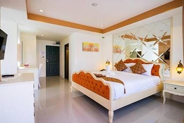Un dormitorio con cama, mesitas de noche y televisor.