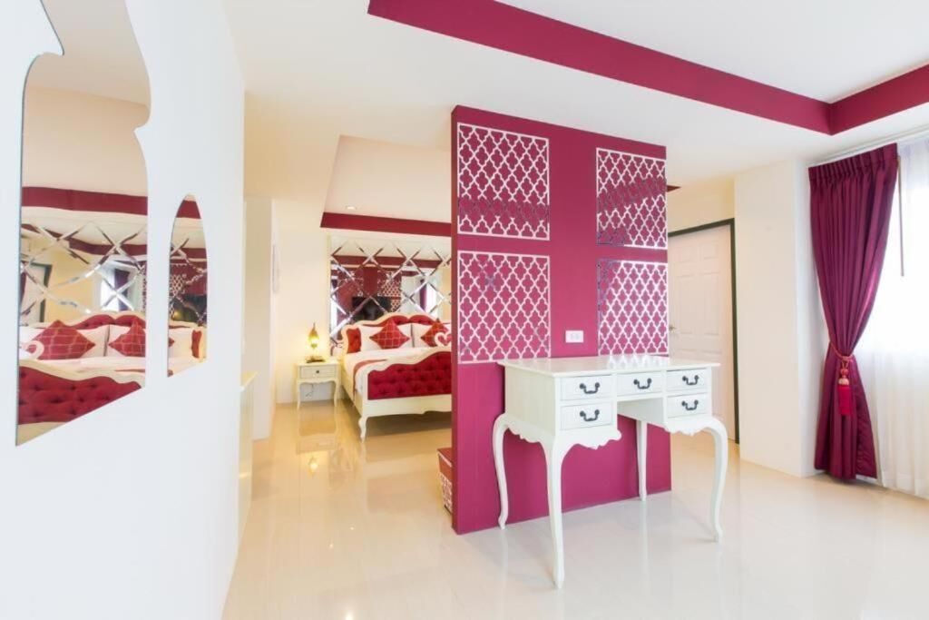 A bedroom with a bed, a dresser, and a decorative partition.
