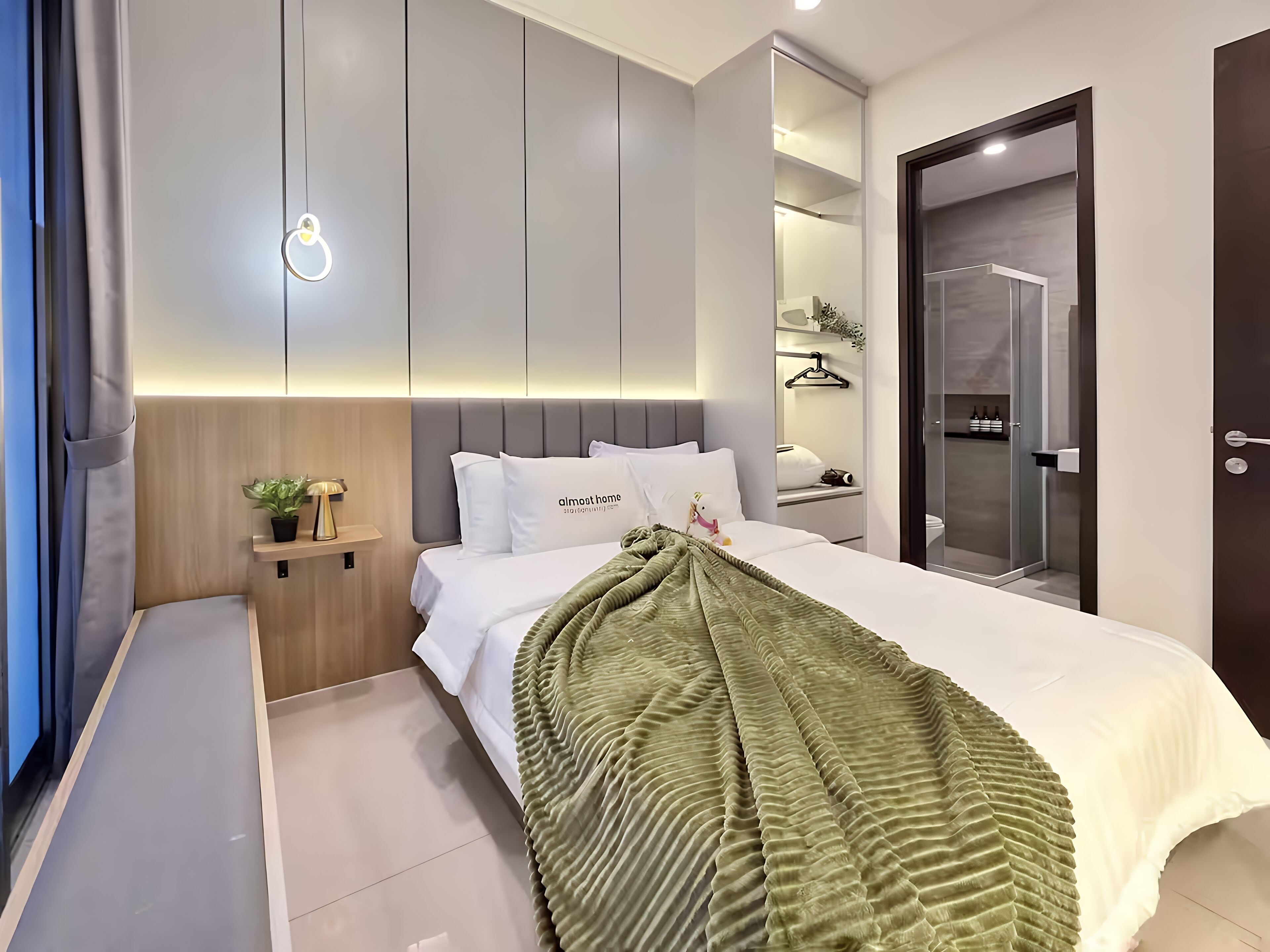 Una habitación de hotel moderna con cama, mesita de noche y espejo.