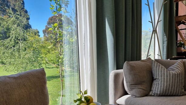 A cozy living room with a sofa, a small table with a bowl of lemons, and a magazine. - The Retreat - Reconnect with nature in style (Musk)