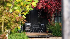 A patio with a grill, two chairs, and a table. - The Retreat - Reconnect with nature in style (Musk)