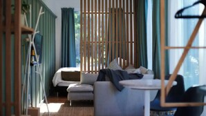 A room with a bed, a sofa, and a window with curtains. - The Retreat - Reconnect with nature in style (Musk)