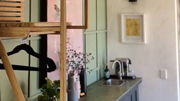 Een keuken met houten balken, een groene wand, een spoelbak en een hangrek.