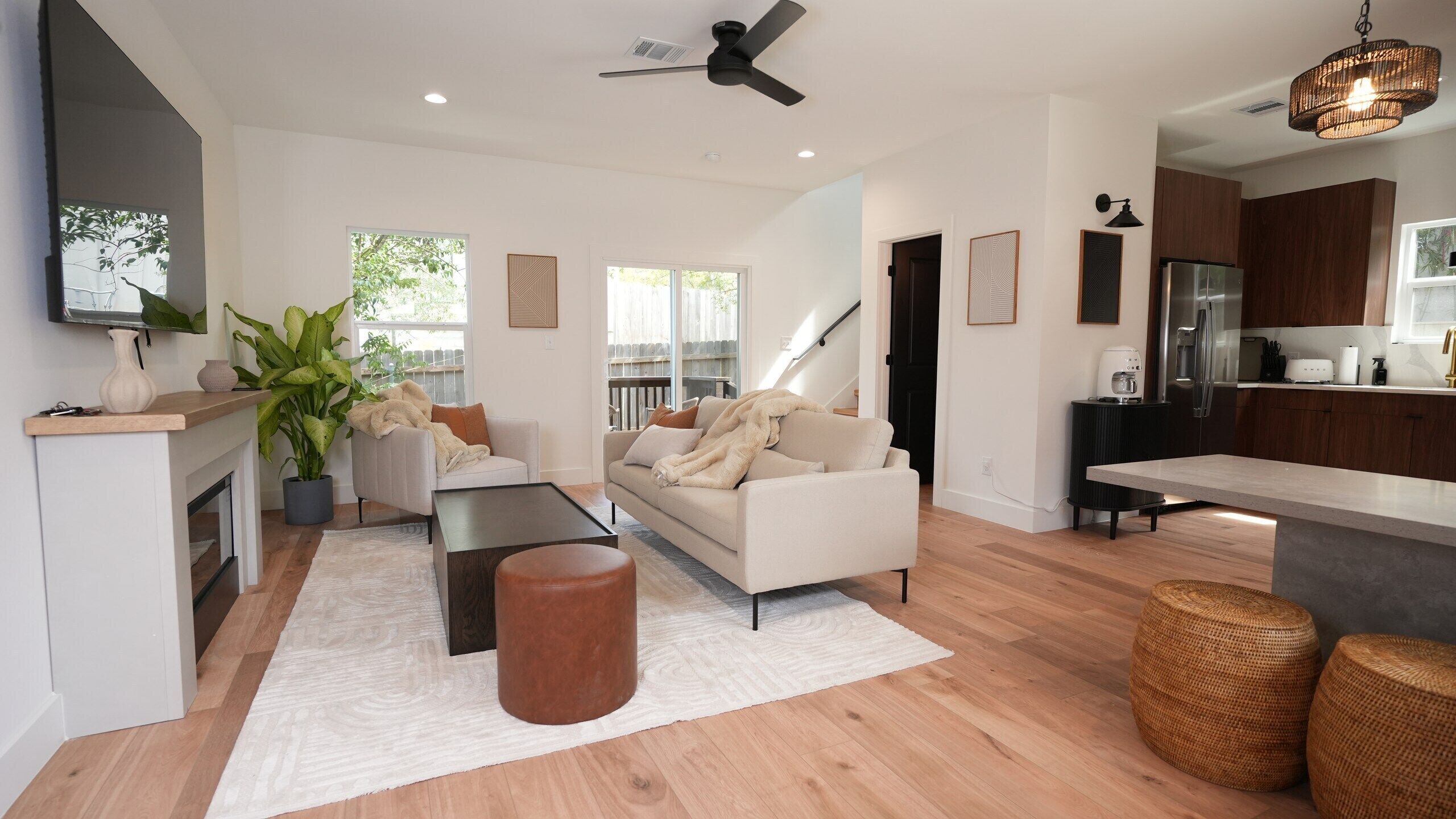 A modern living room with a sofa, coffee table, and a large potted plant.