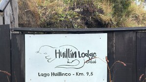 A sign for Huillin Lodge, indicating its location at Lago Huillinco, 9.5 km away. - Huillín Lodge (Chonchi)