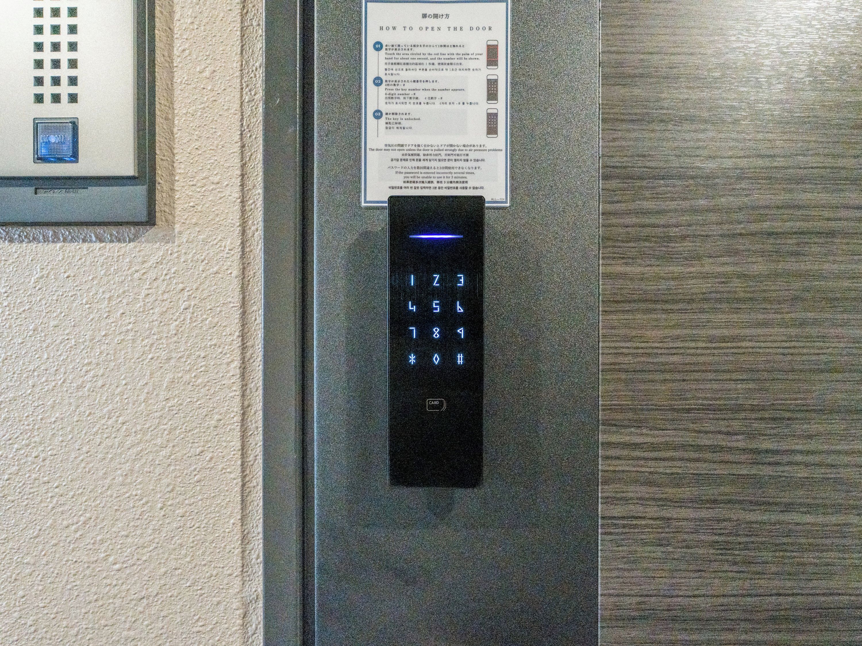 A wall-mounted elevator control panel with a numeric keypad and illuminated buttons.